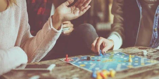 People talking around table with board game